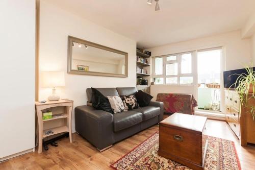 a living room with a couch and a mirror at Central Camden Flat With Terrace For 4 People in London