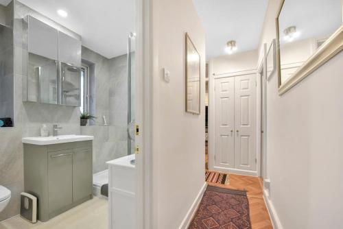 a white bathroom with a sink and a toilet at Central Camden Flat With Terrace For 4 People in London