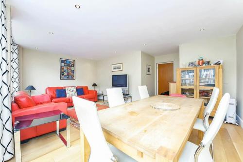 a living room with a table and a red couch at CENTRAL WEST END & THEATRE-LAND 2 Beds & 2 Baths in London