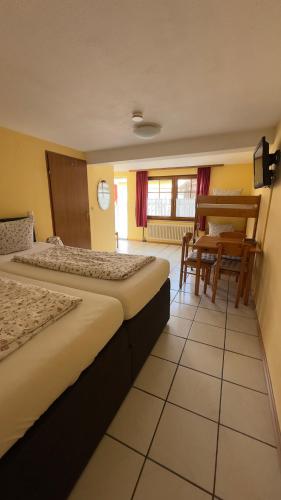 a hotel room with two beds and a table at Pension Chloe in Rust