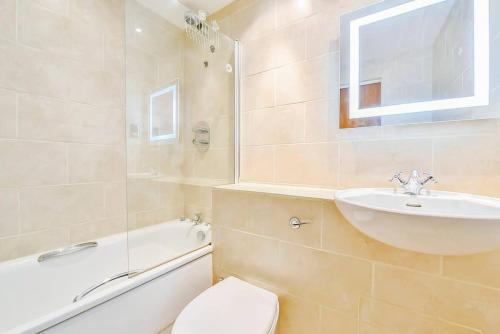 a bathroom with a sink and a toilet and a tub at CENTRAL WEST END & THEATRE-LAND 2 Beds & 2 Baths in London