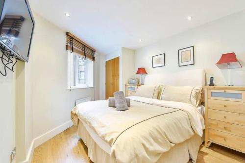 a bedroom with two beds and a flat screen tv at CENTRAL WEST END & THEATRE-LAND 2 Beds & 2 Baths in London