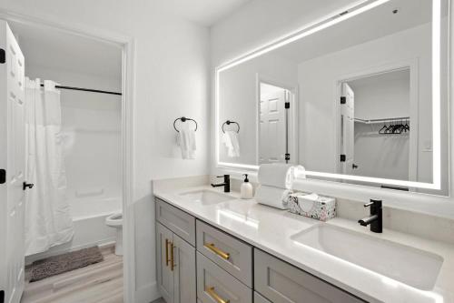 a white bathroom with two sinks and a mirror at CozySuites TPC Scottsdale with parking, pool in Scottsdale
