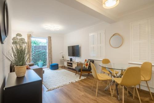 a living room with a glass table and chairs at Lovely 1 Bed Apartment With FREE PARKING & Garden in Cherry Hinton