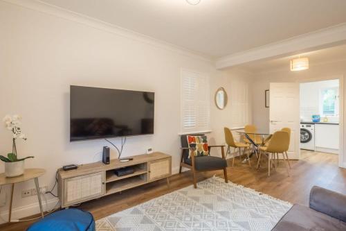 a living room with a flat screen tv on a wall at Lovely 1 Bed Apartment With FREE PARKING & Garden in Cherry Hinton