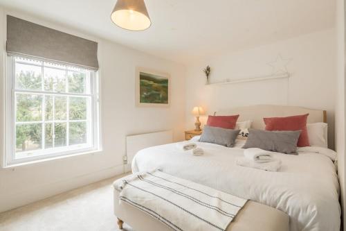 two beds in a white room with a window at Charming Cambridge Cottage With Lovely Garden 