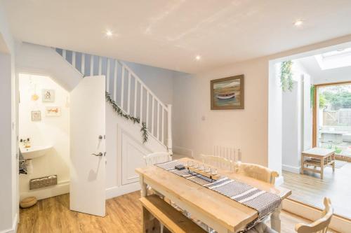 a living room with a wooden table and stairs at Charming Cambridge Cottage With Lovely Garden 