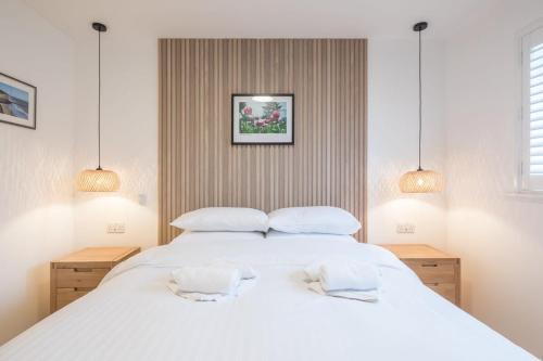 a bedroom with a large white bed with two pillows at Modern & Private - Free Parking in Cherry Hinton