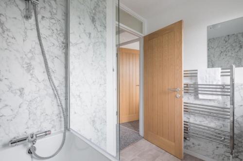 a bathroom with a shower and a glass door at Charming Renovated Family Home in Cherry Hinton