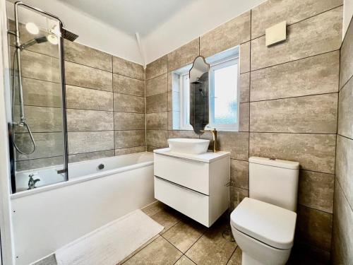 een badkamer met een wastafel, een bad en een toilet bij Rest on Super-King Bed under The Starry Night in Chesterton