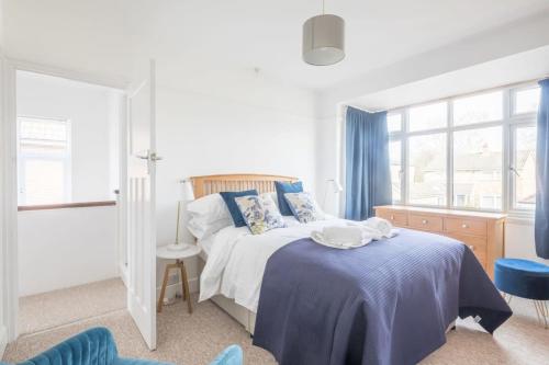 a white bedroom with a bed with a blue blanket at Charming Central Family Home in Cambridge