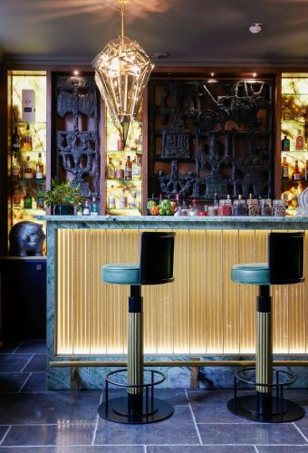 a bar with two stools in front of a counter at Juliana Hotel & Spa - Brussels Centre in Brussels