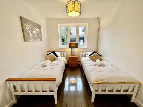 two twin beds in a room with a window at Rest on Super-King Bed under The Starry Night in Chesterton