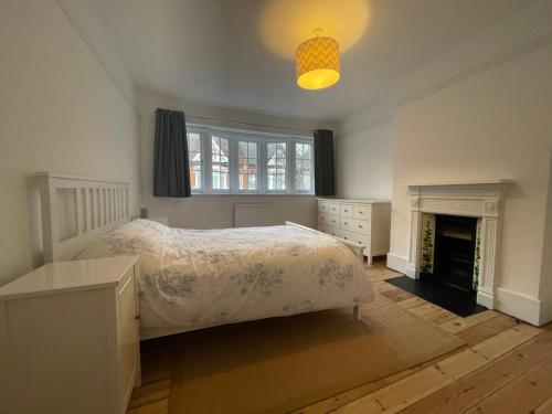 a bedroom with a bed and a fireplace at Beautiful Family Victorian Home in Crystal Palace