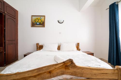 a bedroom with a large bed with a wooden frame at Bonsai Villa in Nairobi