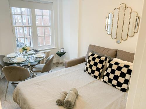 a living room with a bed and a table at Vibrant 2-Bedroom Flat with Elevator in Marylebone, Close to Hyde Park & Edgware Road in London