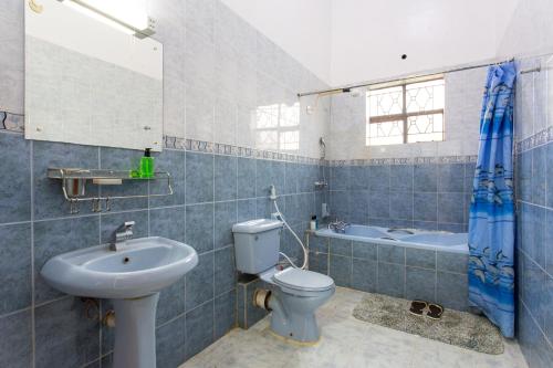 a bathroom with a toilet and a sink and a tub at Bonsai Villa in Nairobi