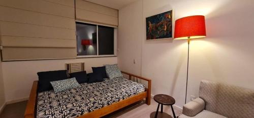una camera con letto, lampada e sedia di Apartamento Confort 804 a Rio de Janeiro