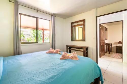 a bedroom with a blue bed with bows on it at Casa Caribbean Coconut in Cahuita