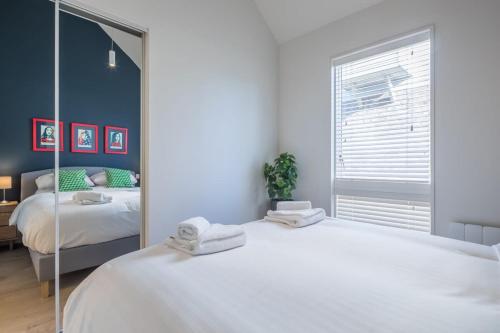 ein Schlafzimmer mit einem großen weißen Bett und einem Spiegel in der Unterkunft Luxury City Centre Apartment Stunning River Views in Cambridge