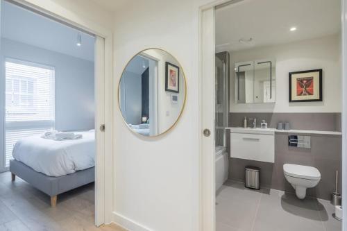a bathroom with a bed and a sink and a mirror at Luxury City Centre Apartment Stunning River Views in Cambridge
