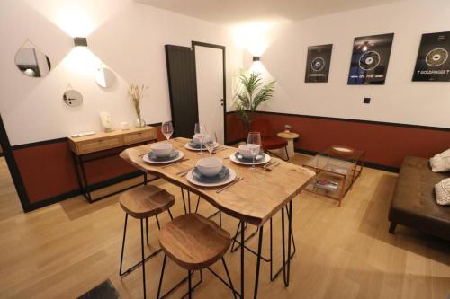 un salon avec une table, des chaises et un canapé dans l'établissement Neuf & Cosy - 2 chambres - 11e, à Paris