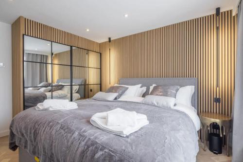a bedroom with a large bed with white towels on it at Luxury 2 Bedroom Apartment with AC and Parking in Cambridge