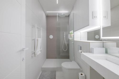 a white bathroom with a toilet and a shower at Luxury 2 Bedroom Apartment with AC and Parking in Cambridge