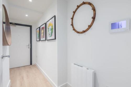 a hallway with white walls and a mirror on the wall at Luxurious City Centre Apartment with Balcony in Cambridge