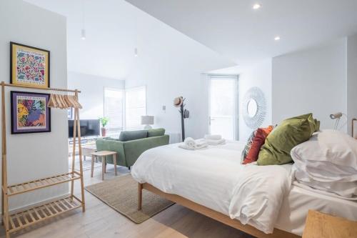 a white bedroom with a bed and a living room at Luxurious City Centre Apartment with Balcony in Cambridge