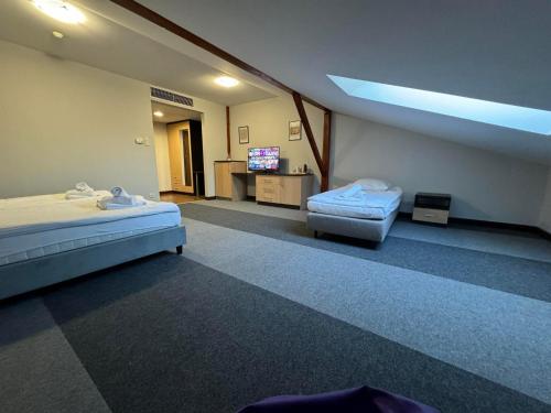 ein Krankenhauszimmer mit 2 Betten und einem TV in der Unterkunft Mąka i Magia Obiady domowe Hotel in Zambrów