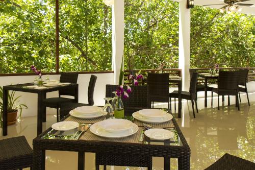 a table with plates on it on a patio at Liberty Guesthouse Maldives in Mahibadhoo