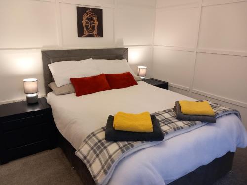 a bedroom with a bed with two towels on it at Springfield Apartment - Train to Glasgow or Edinburgh - Private Parking & Wifi in Airdrie