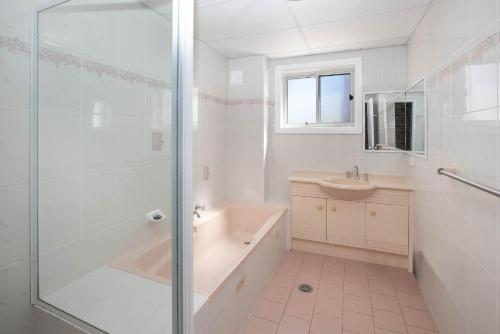 La salle de bains est pourvue d'une douche, d'une baignoire et d'un lavabo. dans l'établissement Mainsail 3, à Port Macquarie