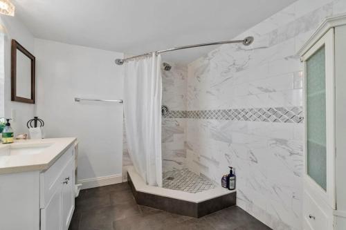 a white bathroom with a shower and a sink at Coconut Walk To The BeachComfy Beds Firepit Pool in Fort Lauderdale