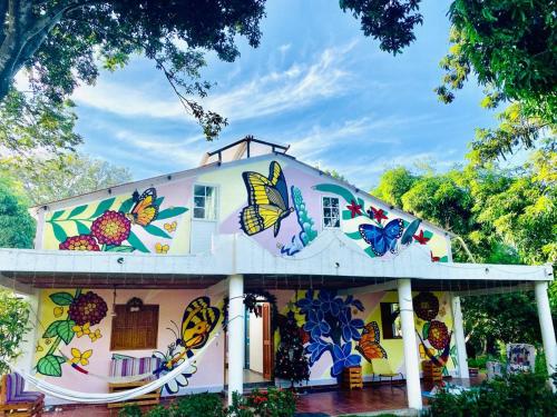 una casa con mariposas pintadas a un lado. en AFRA Reserva Natural, en Santa Marta