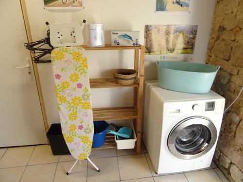 a laundry room with a washing machine and a drying rack at La ferme aux chats in Formigny
