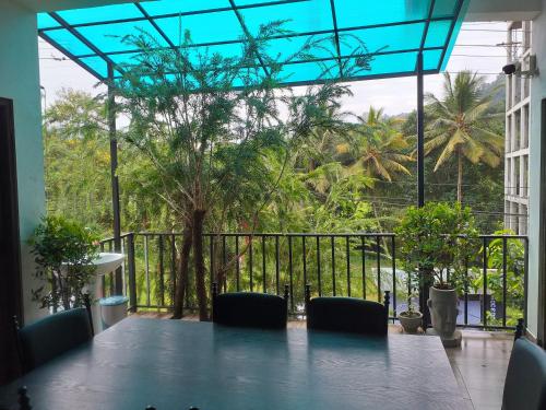 een balkon met uitzicht op een palmboom bij TravelNest in Badulla