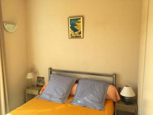 a bedroom with an orange bed with two pillows at Aloès in Cerbère