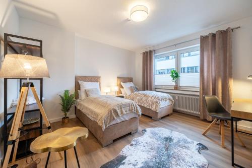1 Schlafzimmer mit 2 Betten, einem Schreibtisch und einem Fenster in der Unterkunft FeWo Vogel: City Wohntraum in Bielefeld