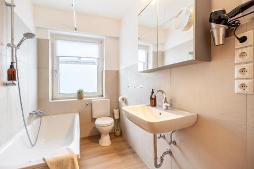 ein kleines Bad mit einem Waschbecken und einem WC in der Unterkunft FeWo Vogel: City Wohntraum in Bielefeld
