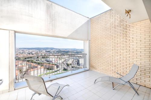 a room with two chairs and a large window at VIVA Stadium Residence Studios in Porto