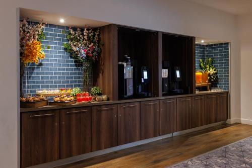 a row of wooden cabinets in a room with food at DoubleTree by Hilton London Angel Kings Cross in London
