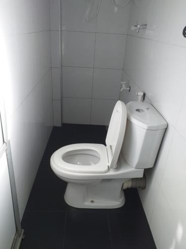een badkamer met een wit toilet in een stal bij TravelNest in Badulla