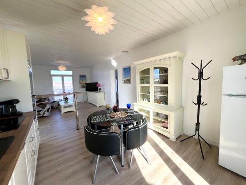 une cuisine et une salle à manger avec une table et des chaises dans l'établissement Ô COURANT - T3 terrasse vue océan, à Mimizan