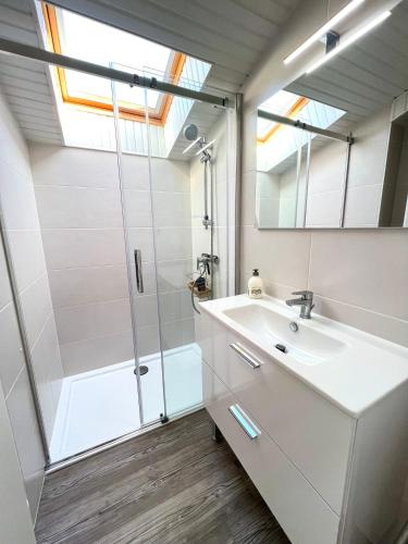 une salle de bain avec une douche, un lavabo et un miroir dans l'établissement Ô COURANT - T3 terrasse vue océan, à Mimizan