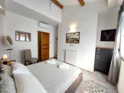 a white bedroom with a bed and a chair at Veracini apartment in Florence