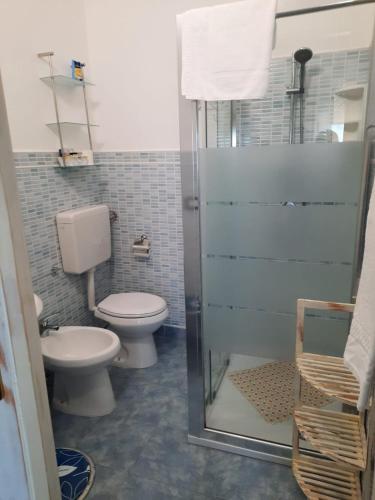 a bathroom with a toilet and a glass shower at Camera Sole in Alghero