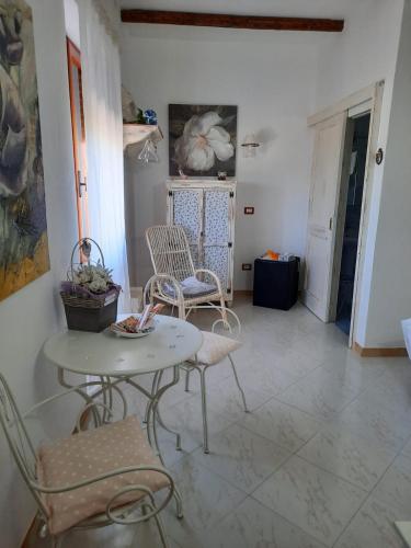 a living room with two chairs and a table at Camera Sole in Alghero