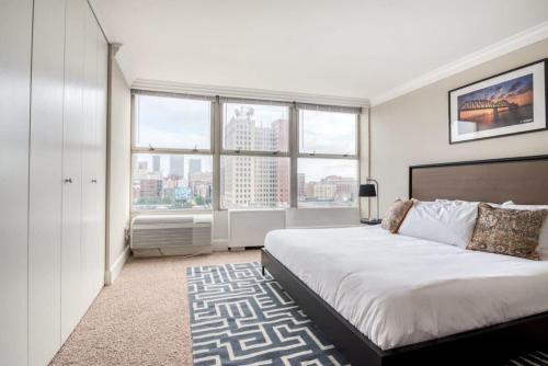 a bedroom with a large bed and large windows at CozySuites 800 Tower 1BR w sky pool, gym! 20 in Louisville